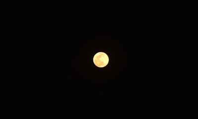 bright yellow full moon floating on sky in night background