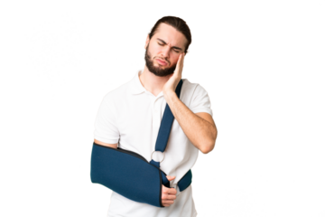 Young handsome man with broken arm and wearing a sling over isolated chroma key background with headache