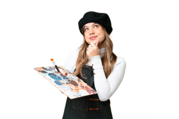 Young artist girl holding a palette over isolated chroma key background and looking up