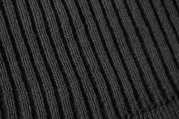Close up dark grey knitted fabric background texture.