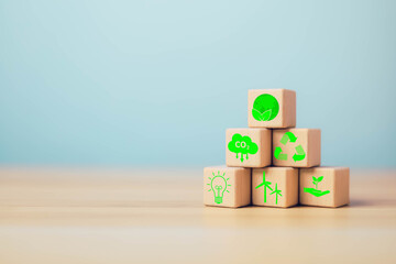 ESG Concepts on Environment, Natural environment, Wooden blocks are stacked on a table with ESG icons on wood block stack, light blue background.