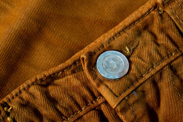 Metallic button on bright brown jeans, fabric texture mockup
