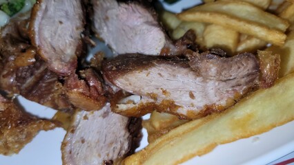 Vue sur une assiette de frites et de canard laqué