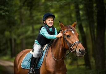 Young boy joyfully riding horse in wooded area during sunny day
