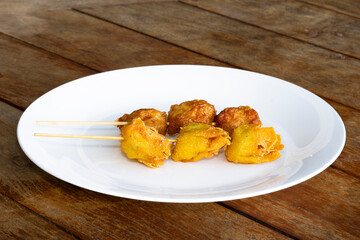 CLose-up view of chine food wanton fried ina white color plate with stick on it