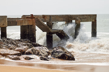 Ancient ruined maritime structure hit by strong waves.