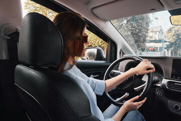 Driver, woman, car a woman sits in the driver's seat of a car, hands on the steering wheel, focused eyes on the road ahead