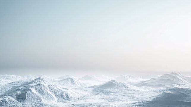 Snowy mountains stretching into foggy distance under pale sky
