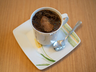 Kubek z zaparzoną kawą sypaną. Kawa po turecku.