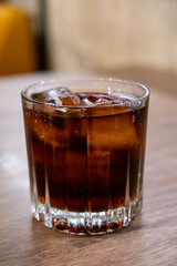 A glass of Cola on the table with blurred background