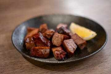 Grilled beef tongue served on plate with lemon