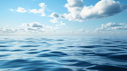 Obraz premium Calm ocean water reflecting blue sky with white clouds