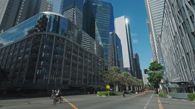 Skyscrapers soar against a bright blue sky in an urban cityscape, Manila, Philippines, 4k