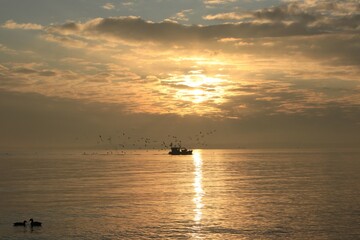 Kleines Fischerboot mit Möwen am Meer. 