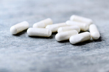 Beta-alanine capsules. Bodybuilding food supplements on wooden background. Soft focus. Close up. Copy space.	