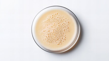 A close-up view of creamy frothy coffee in a glass bowl, showcasing its rich texture and inviting appearance.
