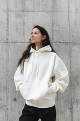 Urban Fashion Hoodie Mockup Against Textured Concrete Wall for Apparel Branding