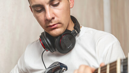Guitarist. Focused man in headset enjoy creative hobby play electric guitar at home. Man musician...