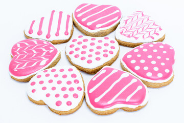 a collection of cookies with pink and white stripes and white frosting in a shape of heart   