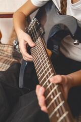 Fototapeta premium Close up. Girl playing electric guitar and practicing at home