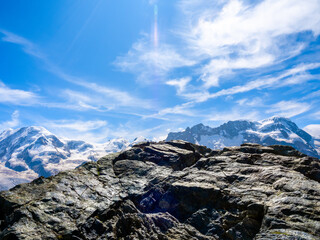 Beautiful black stone on top of mountain range on Swiss Alps with nobody, mountains view with snow on the peaks, mountains landscape on blue sky background, summer season in Zermatt, Switzerland.