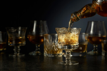 Whiskey is poured from a bottle into a glass.