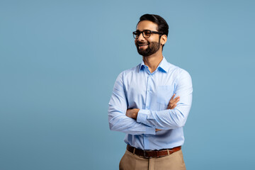 Smiling, Indian man wearing stylish eyeglasses, looking away on copy space. Successful businessman