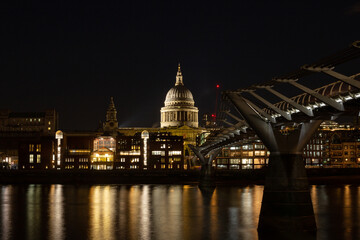 Fototapeta premium Night view of London's iconic Millennium Bridge leading to Saint Paul's Cathedral across the Thames river