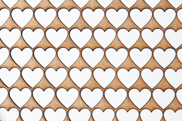 Laser cut heart pattern on HDF board. Repeating heart shapes for decorative backgrounds. Technical love inspired design. Creative and precise laser craftsmanship for romantic projects and wallpapers.