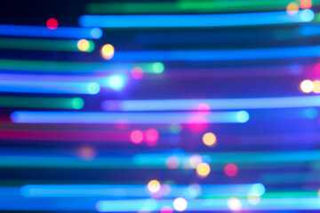 A long exposure photograph. Light painting photography, vibrant multicolour fairy lights in lines and circles against a black background