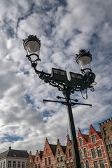 Street lamp in the central square  and the houses with colorful facades. Bruges, Belgium