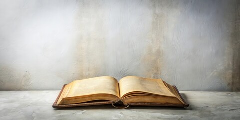 Aged Book Open on Weathered Surface Against Textured Wall