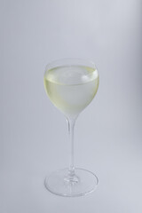 A delicate glass of white wine placed elegantly on a clean white surface