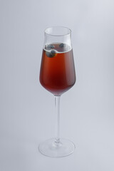 Enjoying a refreshing glass of wine that has a blueberry in it