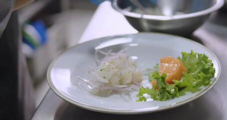 Closeup on the chef's hands wearing gloves, preparing Peruvian Ceviche with fresh vegetables