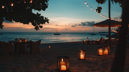 Romantic beach dinner at sunset with candles and string lights.