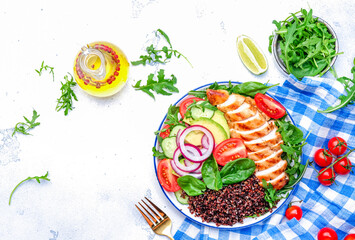 Harvard plate with chicken as protein, quinoa as carbohydrates, vegetable and arugula as fiber, avocado as healthy fats on white background, top view