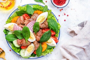 Perigord salad with liver, tomatoes, cucumbers, eggs and lettuce. White background, top view