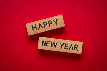 Happy New Year written on wooden blocks on red background