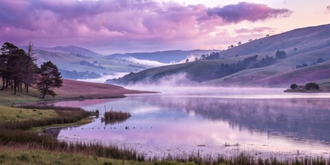 Fototapeta premium Serene Misty Lake Surrounded by Rolling Hills and Reflecting the Soft Light of a Pastel Sky