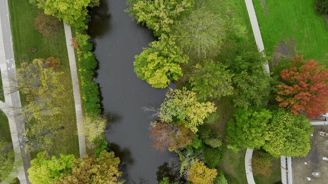 Aerial drone footage of college campus on a cloudy fall day in October in East Lansing Michigan near the red cedar river. College dorms, apartments visible. Beautiful autumn colors everywhere