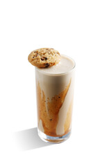 A glass of milkshake with a cookie on top of it