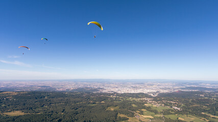 parapente parti du sommet du Puy de dôme en auvergne et survolant la ville de Clermont Ferrand en france en été
