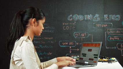 Highschool girl writing code or engineering prompt while attend in STEM technology class. Teenager...
