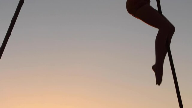 Woman dancing in silhouette on beach
