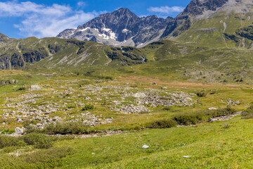 Alps scenic landscape on Tour du Montblanc. Rocky and snow summit peaks of the Alps on the trekking route TMB around Mont Blanc in Chamonix and Courmayeur. Alpine scene with mountains and lakes 