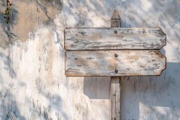 Naklejka premium Sun-bleached wooden signage with weathered texture against a rustic wall in a serene outdoor setting