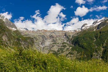 Alps scenic landscape on Tour du Montblanc. Rocky and snow summit peaks of the Alps on the trekking route TMB around Mont Blanc in Chamonix and Courmayeur. Alpine scene with mountains and lakes 