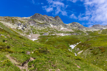Naklejka premium Alps scenic landscape on Tour du Montblanc. Rocky and snow summit peaks of the Alps on the trekking route TMB around Mont Blanc in Chamonix and Courmayeur. Alpine scene with mountains and lakes 