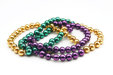 Traditional Mardis Gras beads necklace in purple, gold and green. Carnival celebration throws on white background